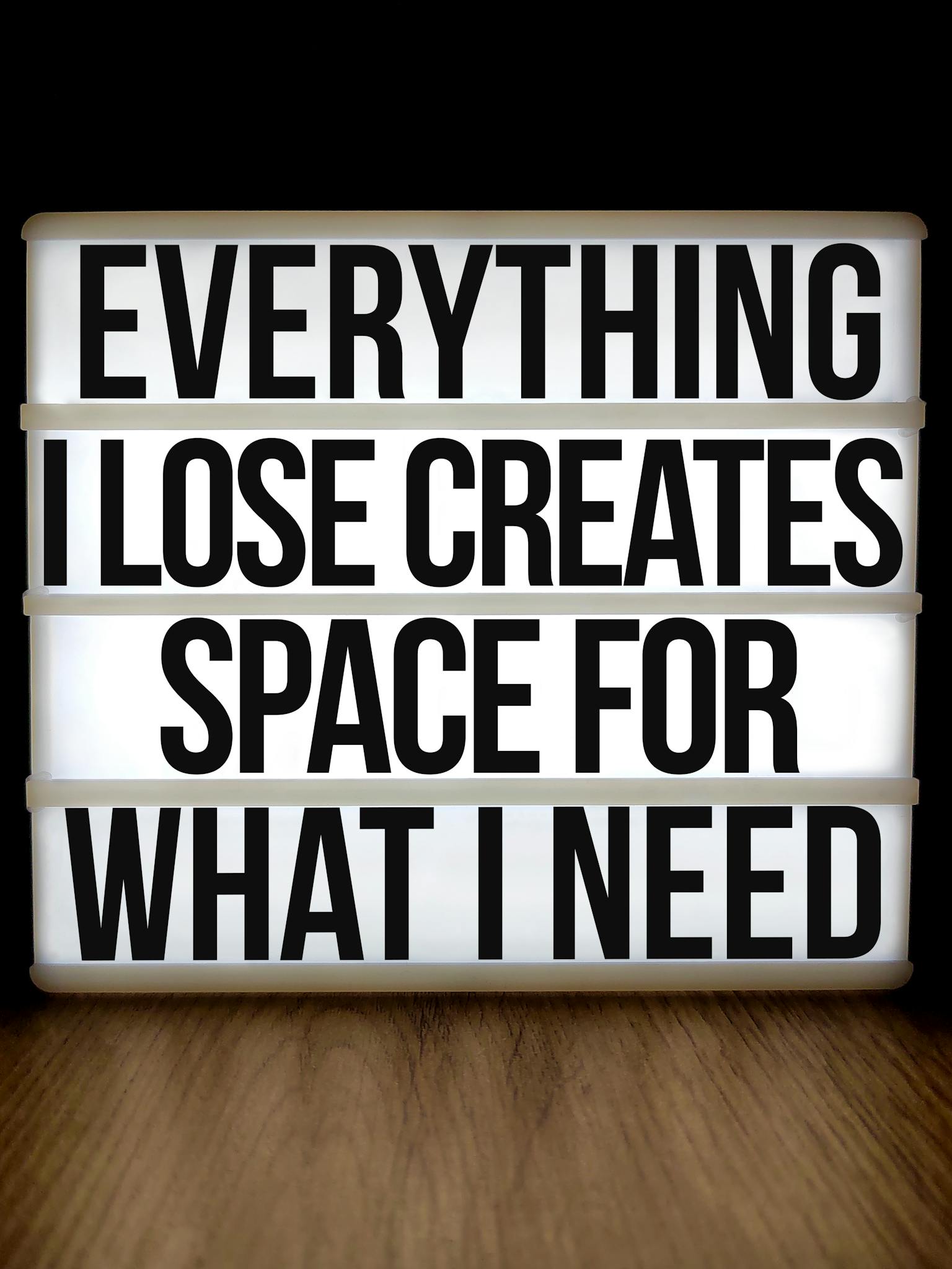 Motivational lightbox with quote: 'Everything I Lose Creates Space for What I Need'.